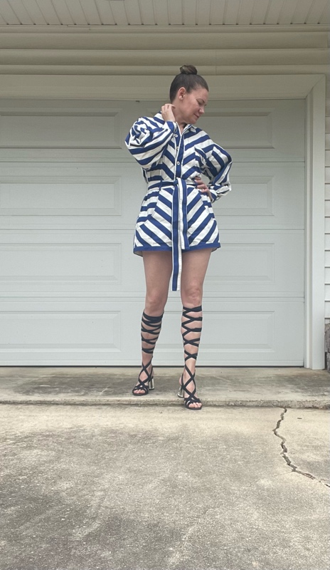 a woman in a blue and white striped romper with lace up navy suede sandals