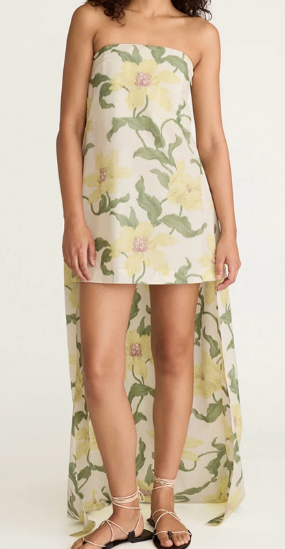 a linen flax dress with green and yellow flowers on it. It's a mini with a maxi back train