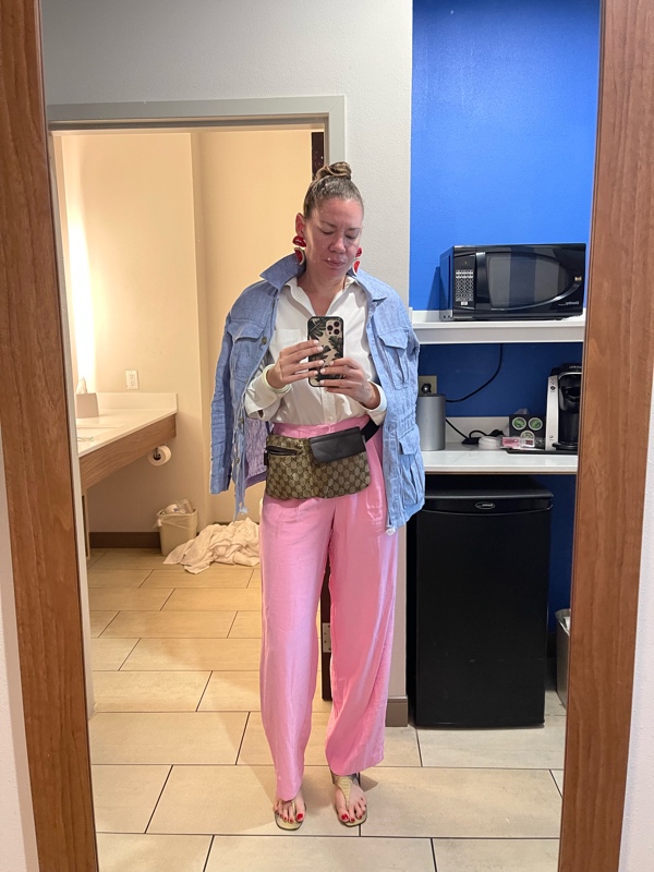 a woman in pink linen pants, snake sandals, a white button down and a blue linen jacket
