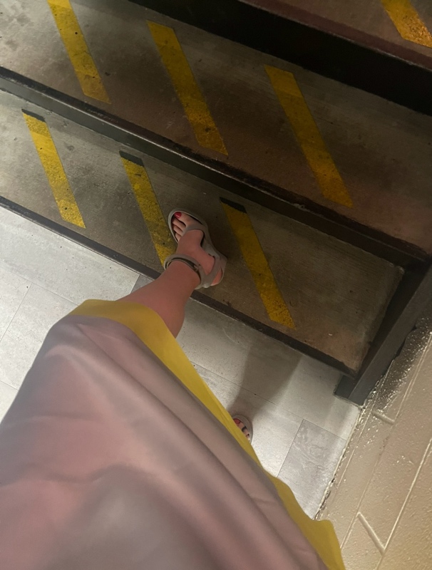 a woman in yellow and grey dress with grey platforms 