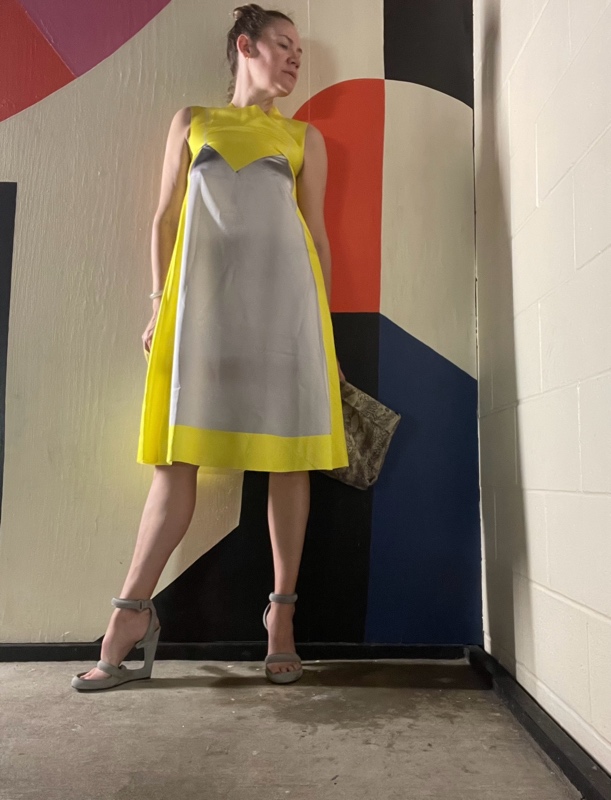 a woman in yellow and grey dress with grey platforms 