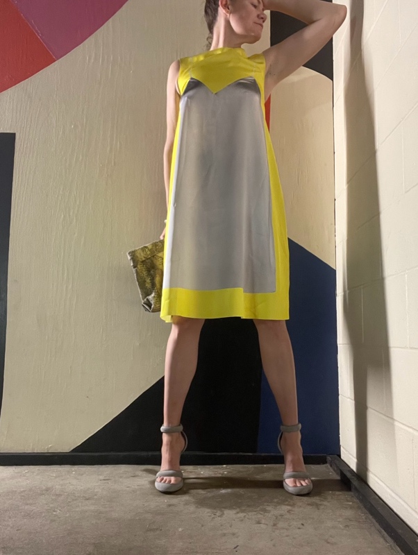 a woman in yellow and grey dress with grey platforms 