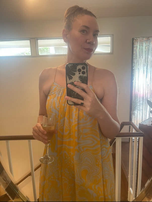 a woman in a blue and gold maxi dress with brown suede platforms