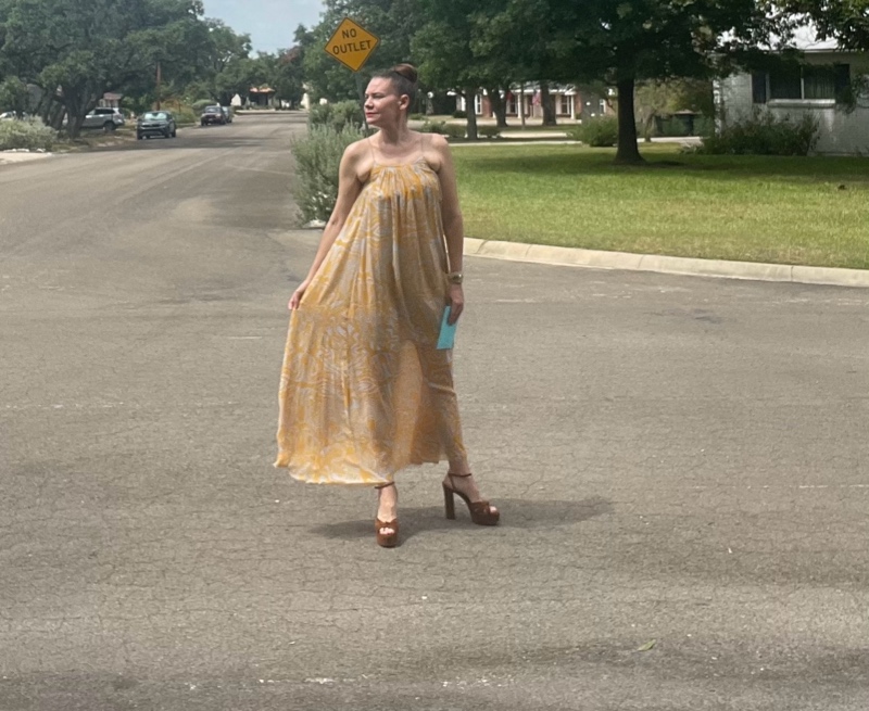 a woman in a blue and gold maxi dress with brown suede platforms