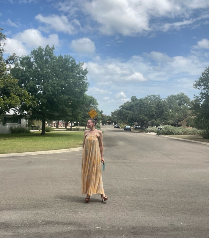 a woman in a blue and gold maxi dress with brown suede platforms