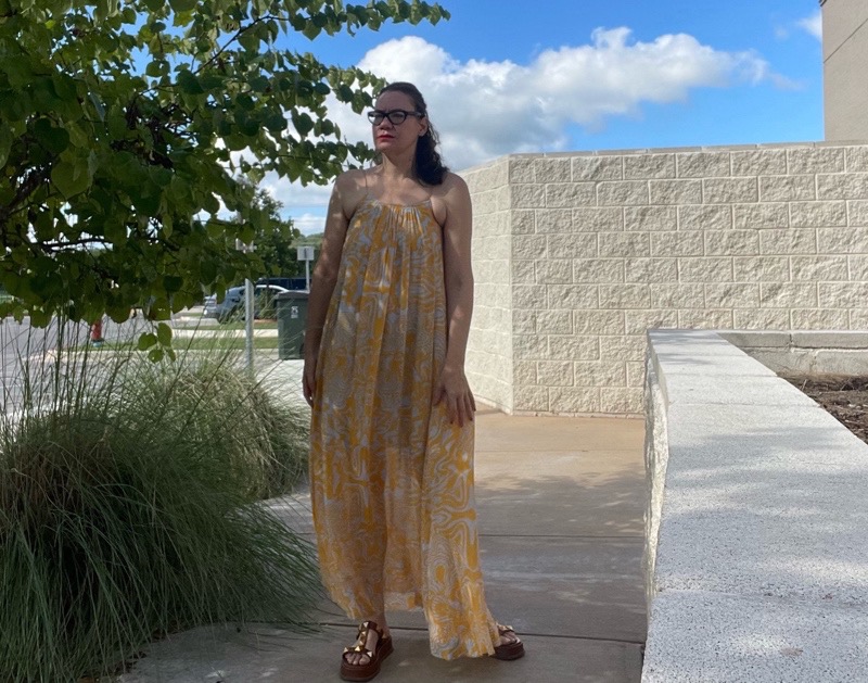 a woman in a blue and gold maxi dress with brown suede platforms