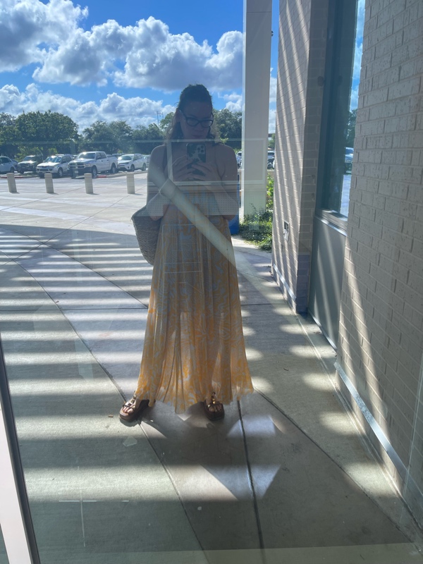 a woman in a blue and gold maxi dress with brown suede platforms