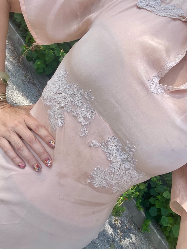 a woman in a vintage peach night gown with flat sandals with fruit charms