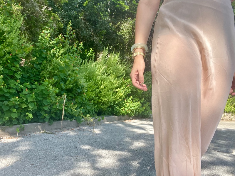 a woman in a vintage peach night gown with flat sandals with fruit charms